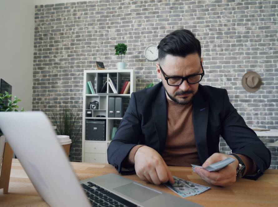 a man sitting at a table in front of a laptop